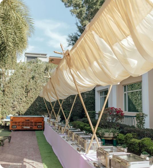 Outdoor hibachi catering buffet setup under a white canopy